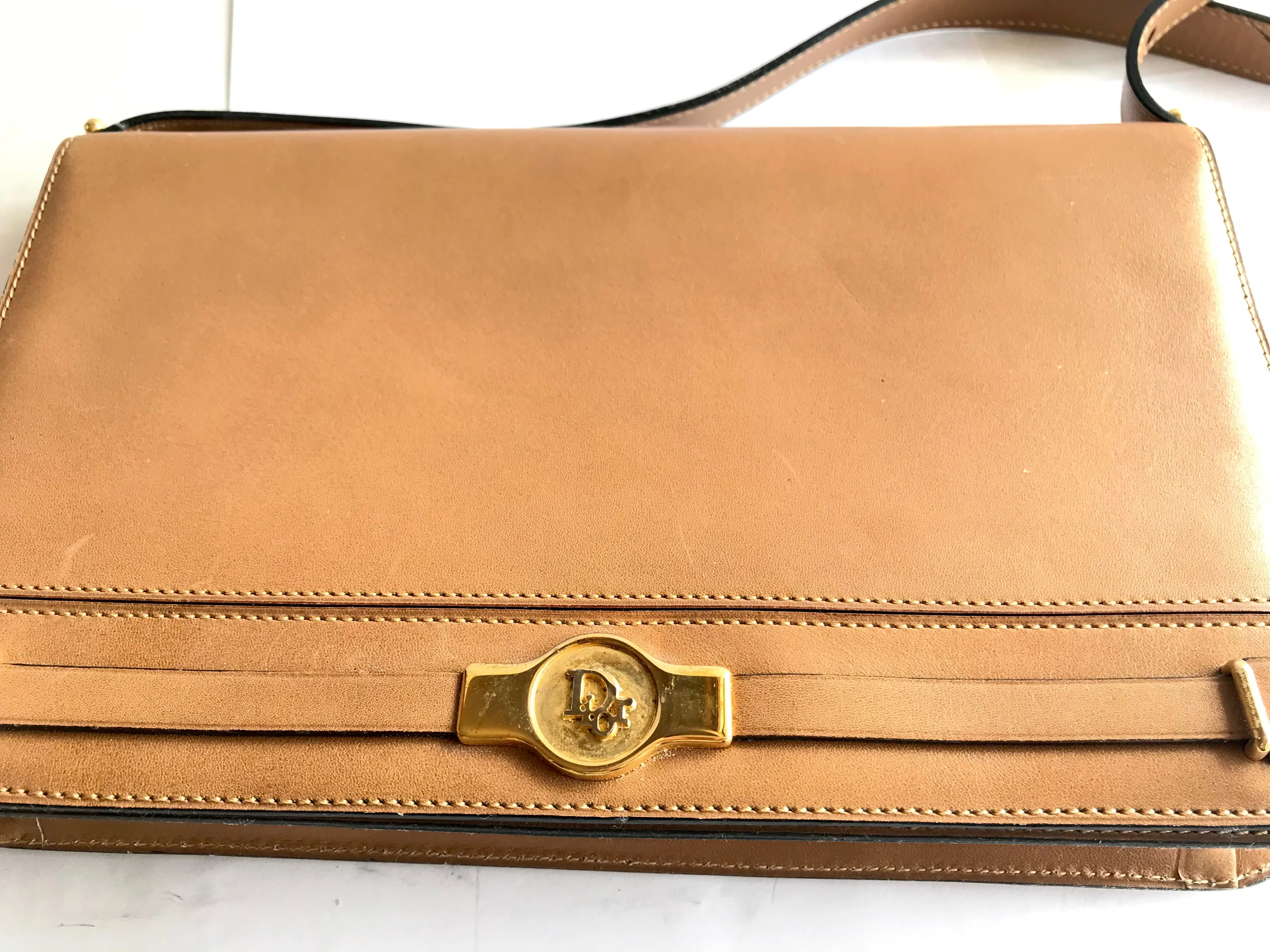 Vintage Christian Dior tanned brown leather shoulder clutch bag with golden CD motif.